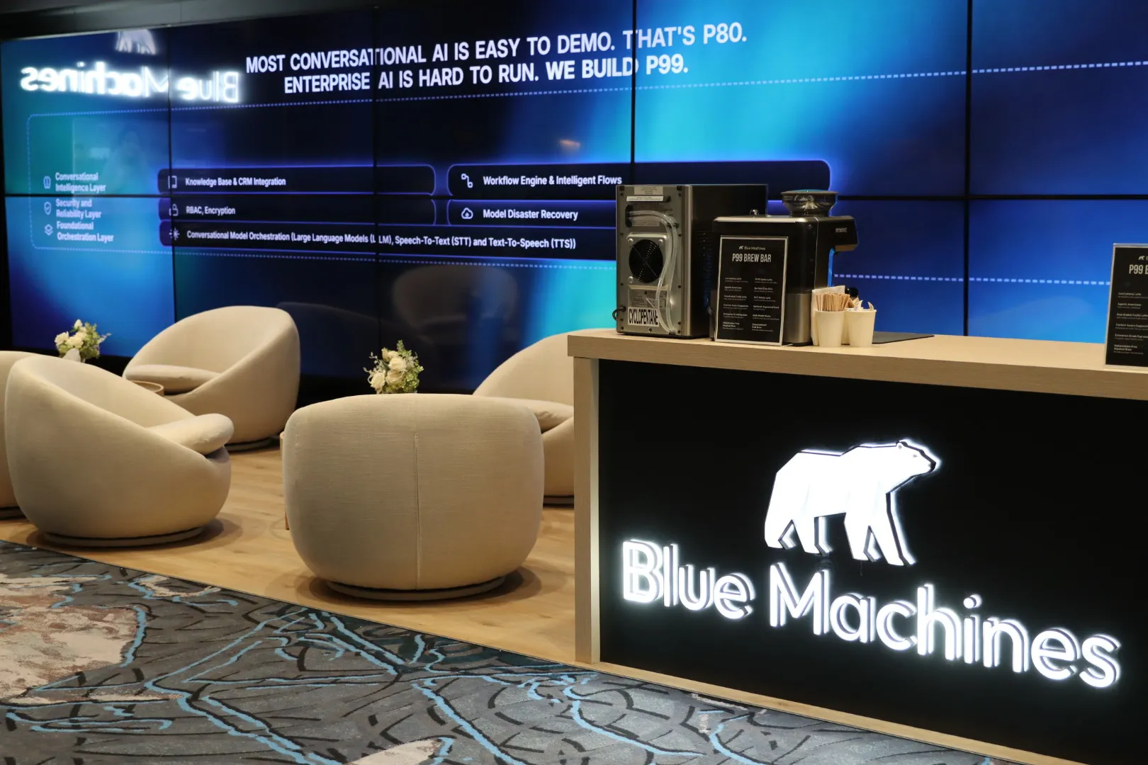 Booth lounge area with sculpted chairs and an illuminated reception counter, custom built in Las Vegas