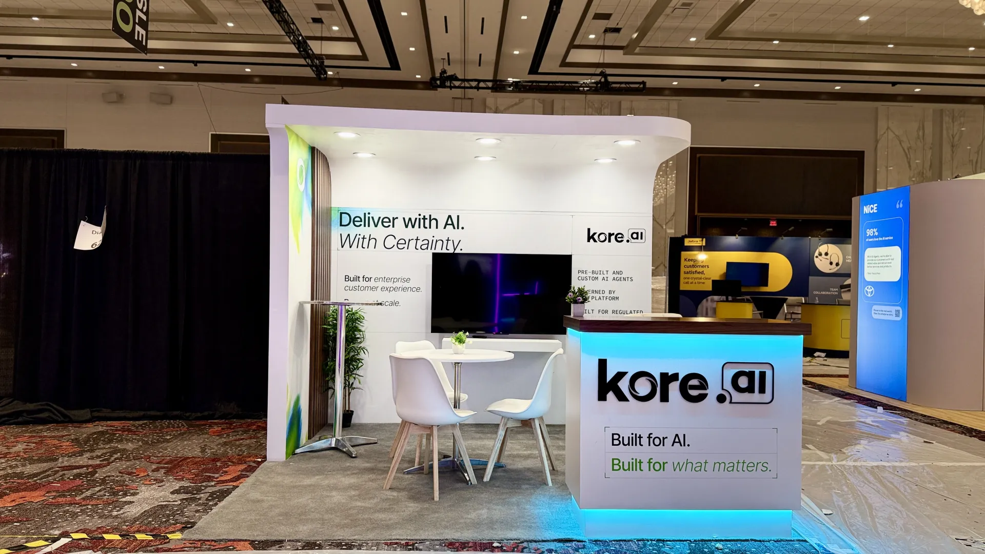 Realized kore.ai booth matching the signed-off 3D design, from archway to backlit desk